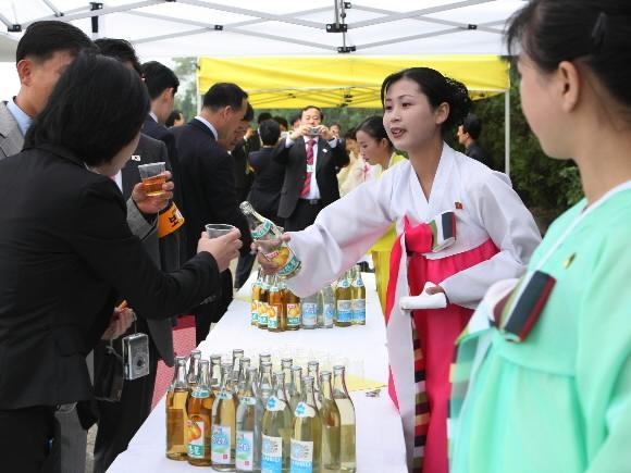 개성-평양간 고속도로 수곡휴게소에서 북측접대원들이 남측 수행원들에게 단물을 서비스하고 있다. 2007.10.02 청와대사진기자단=연합뉴스