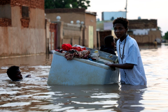 잠기고 아프리카 수단의 수도 하르툼 동쪽에 있는 움둠 지역이 홍수로 침수된 가운데 이재민들이 가재도구를 챙겨 피난을 가고 있다. 움둠 EPA 연합뉴스