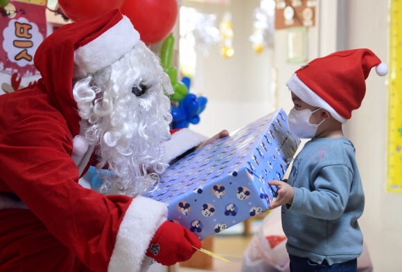 크리스마스를 이틀 앞둔 23일 경기 과천시 한 어린이 집에서 아이들이 어린이집을 방문한 산타클로스로부터 선물을 받고 있다. 2021. 12. 23 박윤슬 기자 seul@seoul.co.kr