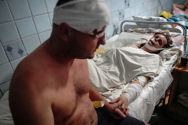 27일(현지시간) 우크라이나 중부 폴타바주(州) 크레멘추크의 한 병원에서 러시아의 쇼핑몰 미사일 공격으로 부상한 한 부부가 치료를 받으며 손을 잡고 있다. 러시아가 이날 민간인으로 붐비던 크레멘추크의 쇼핑몰을 미사일로 공격해 최소 16명이 숨졌다. 이날 공격은 독일에서 열린 주요 7개국(G7) 정상회의에서 러시아에 대한 추가 제재와 우크라이나 지원이 합의된 날 벌어졌다. 2022.6.28 AP연합뉴스