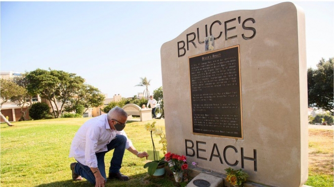 찰스와 윌라 브루스 부부가 흑인들이 드나들 수 있는 해변 리조트를 짓겠다고 매입한 뜻을 기린 기념비를 지난해 4월 20일(현지시간) 랜디 던컨이란 주민이 찾아와 헌화하고 있다. LA 타임스 자료사진 AFP 연합뉴스 