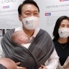 [서울포토] ‘잘 어울리나요?’… 아기띠 체험하는 尹대통령