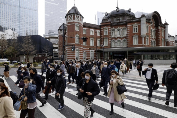 일본 정부가 코로나19 방역을 위한 마스크 착용 의무를 해제한 지난 13일 시민들이 도쿄역 앞을 지나가고 있다. 2023.3.13 교도 AP 연합뉴스