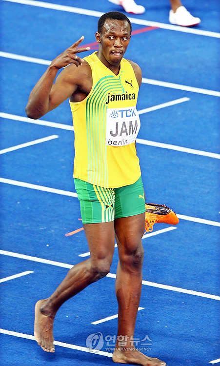독일 베를린 올림피아 슈타디온에서 열린 2009 세계육상선수권대회 남자 400m 계주에서 우승해 대회 3관왕이 된 우사인 볼트(자마이카)가 신발을 벗어들고 관중들을 향해 ‘V’자를 그리고 있다.베를린 연합뉴스