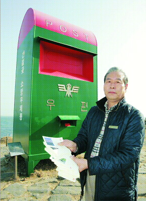 남울산우체국 소포마케팅 김대우 실장이 소망우체통 앞에서 경인년 새해 소망을 담은 사람들의 엽서를 펼쳐 보이고 있다.