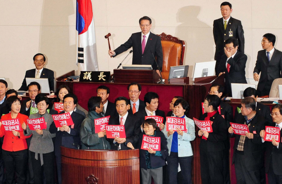 김형오(위) 국회의장이 31일 밤 속개된 본회의에서 민주당과 민주노동당 의원들이 반대하는 가운데 새해 예산안이 가결된 것을 선포하고 있다. 이호정기자 hojeong@seoul.co.kr