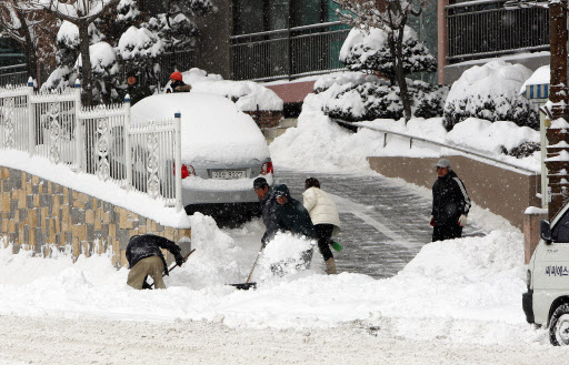 지난 4일 충북 제천에 27.5㎝의 폭설이 내려 도로 곳곳이 마비된 가운데 일부 시민들이 집앞에 쌓인 눈을 치우고 있다. 연합뉴스