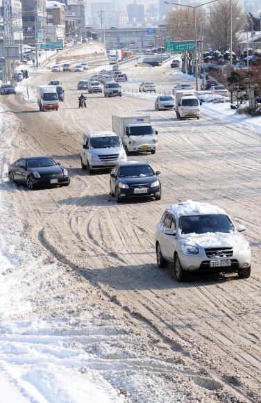 아직도  5일 오전 서울 이촌동의 한 이면도로에는 제설작업이 제때 이뤄지지 못해 쌓인 눈이 그대로 얼어붙으면서 차량들이 거북이 운행을 하고 있다. 손형준기자 boltagoo@seoul.co.kr