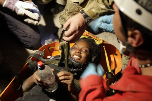 그래도 희망은 있다  아이티 지진 발생 8일째인 19일(현지시간) 수도 포르토프랭스의 붕괴된 건물에서 프랑스 구조대에 의해 구조된 25세의 여성이 물병을 손에 쥔 채 안도의 미소를 짓고 있다. 세계 각국에서 파견된 2000명에 가까운 구조대원들은 아이티 전역에서 단 한 명의 소중한 생명이라도 더 구하기 위해 안간힘을 쓰고 있다. 포르토프랭스 AP 특약