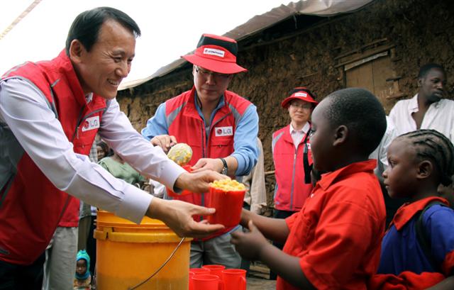 김영기(왼쪽) 부사장이 케냐의 ‘LG희망학교’를 방문해 어린이들에게 먹을 거리를 나눠주고 있다. LG전자 제공