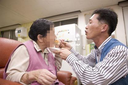 올해 집배원 대상 수상자인 황성화(오른쪽)씨가 노인의 식사를 돕고 있다. 우정사업본부 제공