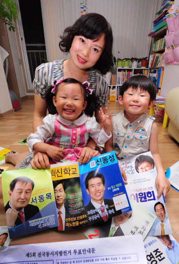 지난해 귀화해 선거권을 얻은 왕봉원씨가 1일 서울 내발산동 자택에서 자녀들과 함께 투표 안내문과 교육감 선거 공보물을 펼쳐 보이고 있다. 이언탁기자 utl@seoul.co.kr