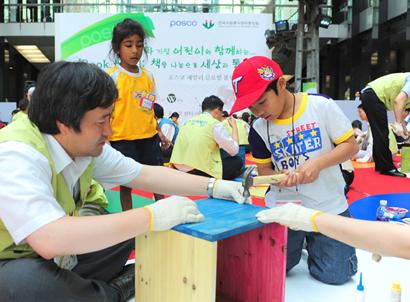 지난 19일 서울 포스코센터에서 다문화 가정 어린이들이 포스코 직원들과 함께 독서 상자를 만들고 있다.  포스코 제공