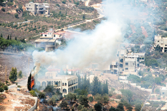 이스라엘군과 레바논군이 3일 오후 무력 충돌, 최소 4명이 숨진 국경지대의 레바논 쪽 마을에서 연기와 함께 불길이 일고 있다. 예루살렘 신화 연합뉴스