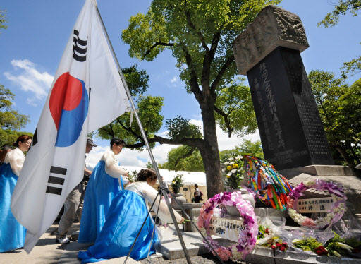 일본 히로시마 원폭 투하 65년을 하루 앞둔 5일 히로시마 평화공원에 세워진 ‘한국인 원폭 희생자 추모비’ 앞에서 한복을 차려입은 재일 동포들이 희생자들의 넋을 기리며 헌화하고 있다. 히로시마 AFP 연합뉴스