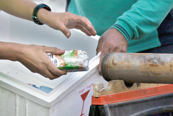 칠레 광부 33명이 먹을 시리얼 바를 25일(현지시간) 구조대원들이 내려보내고 있다. 칠레 정부는 이 관을 통해 음식과 편지 등 물품을 넣어주고 있다.  코피아포 AP 특약