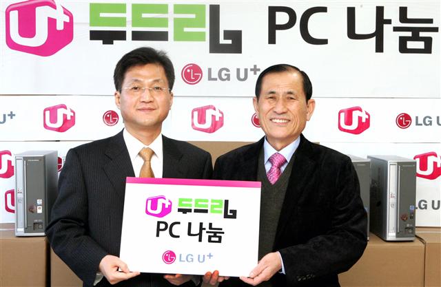 유필계(왼쪽) LG유플러스 부사장이 지난 25일 최정부 강원도 장애인재활협회 회장에게 컴퓨터 기증서를 전달하고 있다.  LG유플러스 제공 