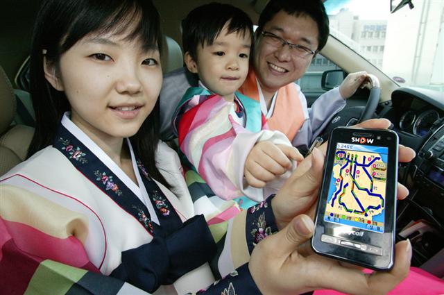 한복차림의 가족이 차 속에서 스마트폰의 무료 내비게이션 앱을 작동하고 있다.  KT제공 