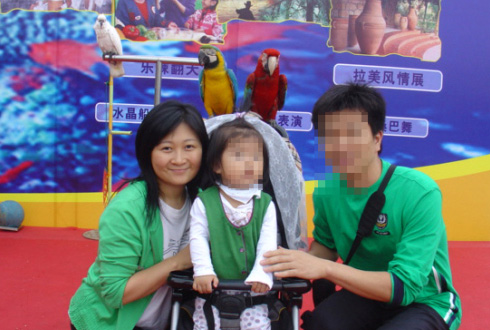 덩신밍이 2005년 10월 중국의 한 유원지에서 가족나들이를 하며 취한 포즈.