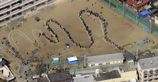 일본 도호쿠 지역에서 발생한 강진으로 피해가 속출하고 있는 가운데 13일 미야기현 센다이 시민들이 시내 한 학교에서 물을 구하기 위해 줄을 지어 서 있다.  센다이 교도 연합뉴스