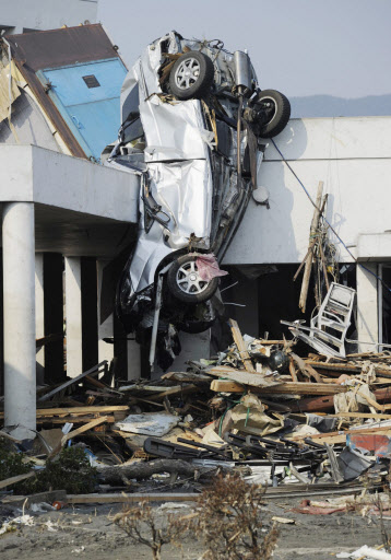 일본 동북부 지방에 발생한 사상 초유의 지진으로 피해가 확산되는 가운데 13일 일본 미야기현 케센누마시에서 쓰나미에 휩쓸린 자동차가 건물에 매달려 있다. 연합뉴스