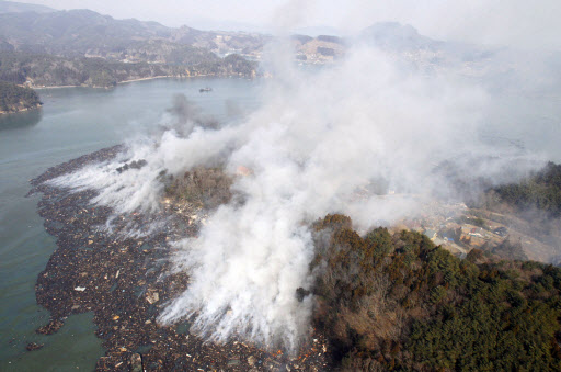 일본 동북부지역에서 발생한 강진으로 피해가 속출하고 있는 가운데 미야기현 게센누마시 한 해안에 퍼져있는 표류물이 불타고 있다.  연합뉴스