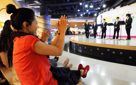 ⑥ 2000년 5월에 개장한 아시아 최대 쇼핑몰인 코엑스몰을 찾은 시민들이 강남합창단의 공연을 관람하며 손뼉을 치고 있다.