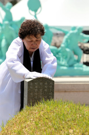 가족을 잃은 어머니의 슬픔은 세월이 흘러도 변함이 없다. 5.18 광주민주화운동 31주년 기념식을 하루 앞둔 17일 오전 광주 북구 운정동 국립 5.18민주묘지에서 한 오월 어머니가 묘비를 쓰다듬고 있다. 연합뉴스