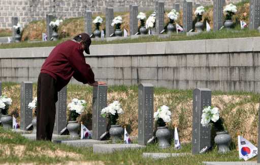 5.18 광주민주화운동 31주년 기념식을 하루 앞둔 17일 오전 광주 북구 운정동 국립 5.18민주묘지에서 한 유족이 묘비를 어루만지고 있다.  연합뉴스