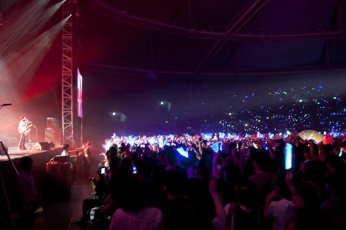 야광봉을 흔들며 공연을 즐기는 열정적인 관객들.