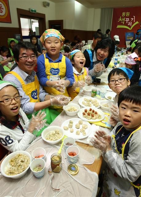 지난해 10월 ‘와글와글 책꾸러기’ 행사에서 안도현(왼쪽) 시인과 어린이들이 어울려 요리를 하고 있다.  동원그룹 제공