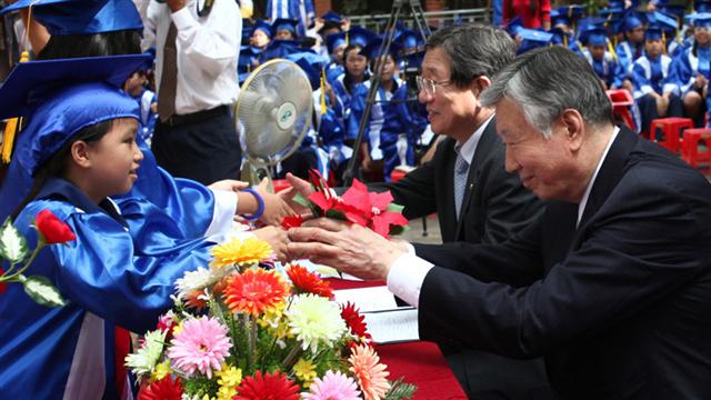 이중근(오른쪽) 부영그룹 회장이 30일 호찌민 응우옌타이썬 초등학교 졸업 행사에서 졸업생 대표로부터 감사의 꽃을 받고 있다.  부영그룹 제공 