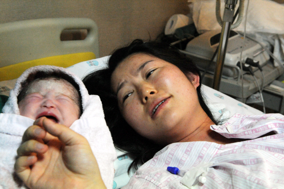 자연분만으로 둘째 딸을 순산한 김진순씨가 아기와의 감격스러운 첫 만남을 갖고 있다.
