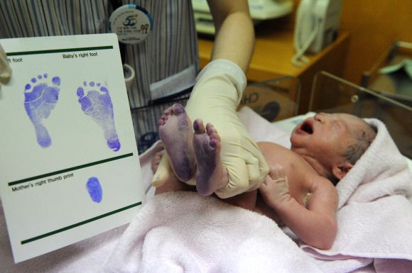 분만실에서 갓 태어난 아기의 확인을 위한 발도장을 찍고 있다.