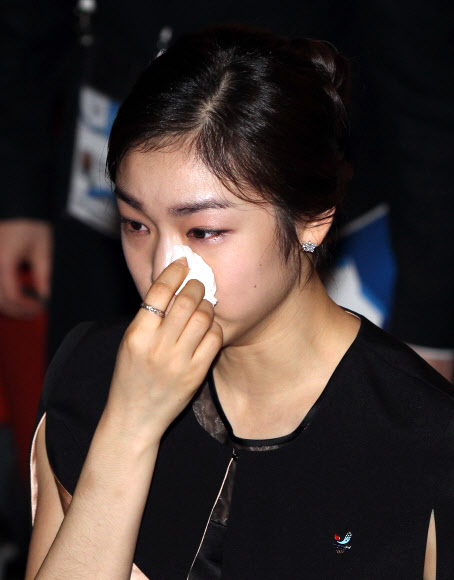 평창유치위 홍보대사인 김연아가 6일(현지시간) 남아프리카공화국 더반 국립컨벤 센터에서 열린 2018동계올림픽 개최도시 발표식에서 평창 유치가 발표된 뒤 눈물을 닦으며 걸어나오고 있다. 연합뉴스