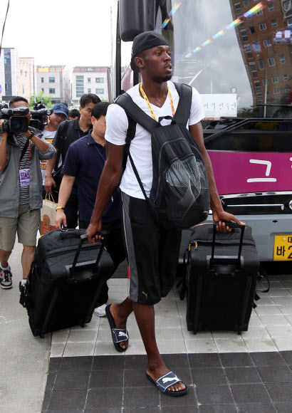 자메이카의 우사인 볼트(앞)가 23일 대구 동구 율하동의 선수촌으로 가방들을 끌며 들어가고 있다. 대구 연합뉴스