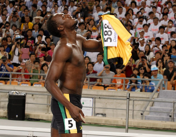 28일 대구스타디움에서 열린 세계육상선수권대회 남자 100m 결승에서 금메달이 유력시되던 자메이카의 우사인 볼트가 뜻밖의 부정 출발로 실격한 뒤 윗옷을 벗어 든 채 허탈함을 감추지 못하고 있다. 볼트는 출발 총성이 울리기도 전에 몸을 움직여 실격당했다. 팀 동료인 요한 블레이크가 9초 92로 우승을 차지했다. 대구 연합뉴스