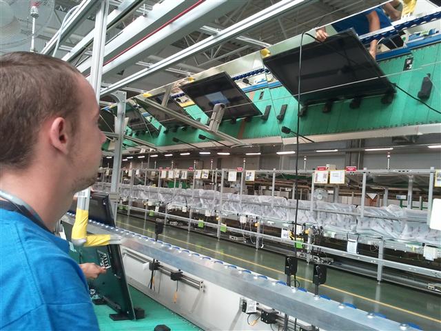 지난 5일(현지시간) 폴란드 브로츠와프 LG전자 공장의 한 근로자가 라인에 설치된 거울을 통해 시네마 3D TV의 불량 여부를 확인하고 있다. 이 공장에서는 라인에 거울을 설치해 한 사람이 TV의 앞면과 뒷면을 동시에 검수할 수 있도록 해 검수 인력을 절반으로 줄였다.
