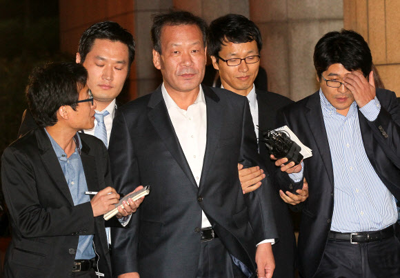 김두우(가운데) 전 청와대 홍보수석이 지난달 28일 새벽 구속돼 서울구치소로 향하던 중 기자들의 질문을 받고 있다. 연합뉴스