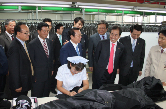 30일 북한 개성공단을 실무 방문한 한나라당 홍준표(오른쪽 세 번째) 대표가 공단 관계자들과 함께 입주 기업인 주식회사 신원 공장을 둘러보고 있다.  통일부 제공