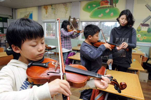 연평초등학교 교실에서 옹진군이 마련한 ‘찾아가는 음악치료’ 프로그램에 참여한 학생 50여명이 밀레니엄오케스트라 단원으로부터 바이올린을 배우고 있다.   연평도 도준석기자 pado@seoul.co.kr
