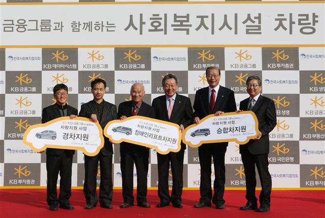 어윤대(오른쪽 세 번째) KB금융지주 회장은 지난 9일 소외계층 지원을 위한 복지차량 51대를 차흥봉(오른쪽 두 번째) 한국사회복지협의회 회장에게 전달했다. KB금융지주 제공