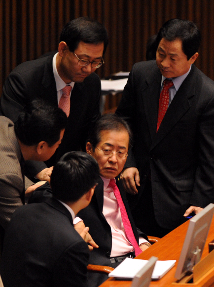 쇄신 대책 논의?  홍준표(가운데) 한나라당 전 대표가 29일 오전 국회 본회의장에서 심각한 표정으로 의원들과 이야기하고 있다.  이언탁기자 utl@seoul.co.kr