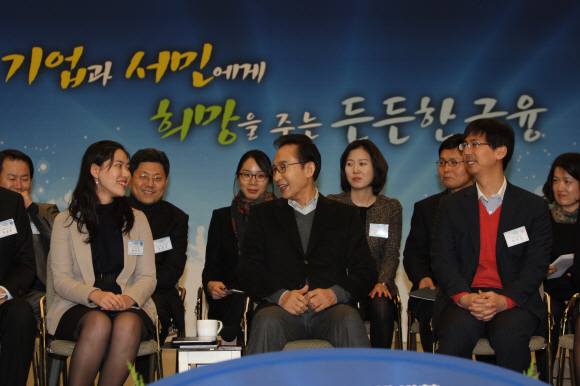 이명박(가운데) 대통령이 30일 서울 종로구 중소기업은행 본점에서 열린 2012년 금융위원회 업무보고에 앞서 참석자들과 앉은 채로 인사를 나누고 있다. 청와대사진기자단