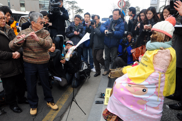 13일 서울 주한 일본 대사관 건너편에 있는 평화비(위안부 소녀상) 앞에서 노무라 모토유키 목사가 일본군 위안부 피해자에 대한 위로와 사과의 뜻으로 가곡 ‘봉선화’를 플루트로 연주하고 있다. 이종원 선임기자 jongwon@seoul.co.kr