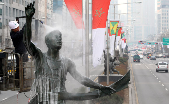 7일 오전 송파구 올림픽로에서 청소업체 직원들이 마라톤상 ‘내일을 향하여’를 시작으로 올림픽 조형물 43점에 대한 봄맞이 세척작업을 하고 있다.  연합뉴스