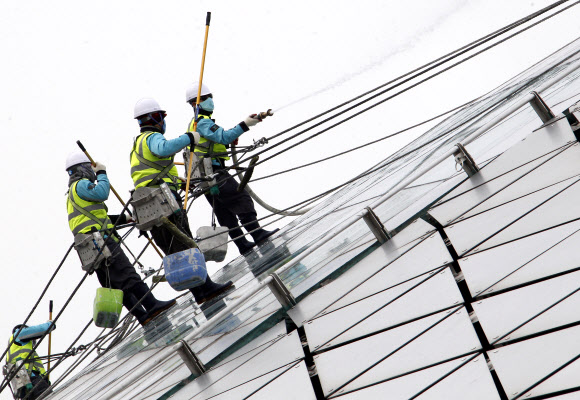9일 오전 영종도 인천공항에서 실시된 핵안보정상회의 맞이 환경 정비 행사에서 관계자들이 교통센터 외벽의 유리창을 물청소하고 있다.  연합뉴스
