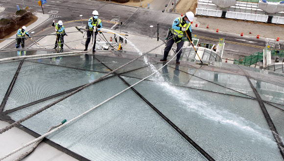 9일 오전 영종도 인천공항에서 실시된 핵안보정상회의 맞이 환경 정비 행사에서 관계자들이 교통센터 외벽의 유리창을 물청소하고 있다.  연합뉴스