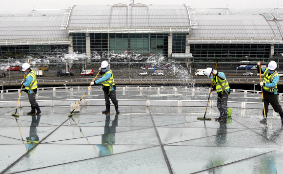 9일 오전 영종도 인천공항에서 실시된 핵안보정상회의 맞이 환경 정비 행사에서 관계자들이 교통센터 외벽의 유리창을 물청소하고 있다.  연합뉴스