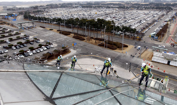 9일 오전 영종도 인천공항에서 실시된 핵안보정상회의 맞이 환경 정비 행사에서 관계자들이 교통센터 외벽의 유리창을 물청소하고 있다.  연합뉴스